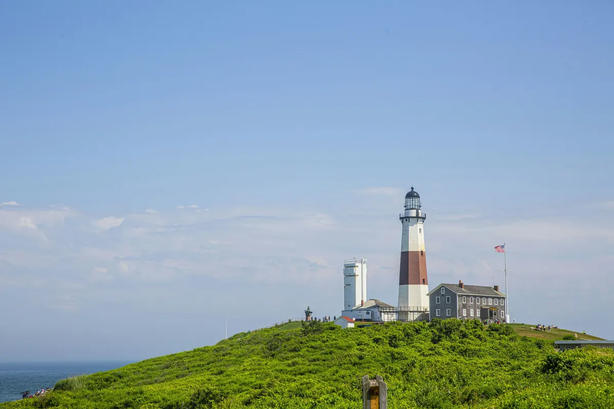 Montauk Point Lighthouse on a green bluff under a bright summer sky